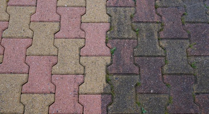 Before and after comparison of block paving, dull on one side and clean on the other
